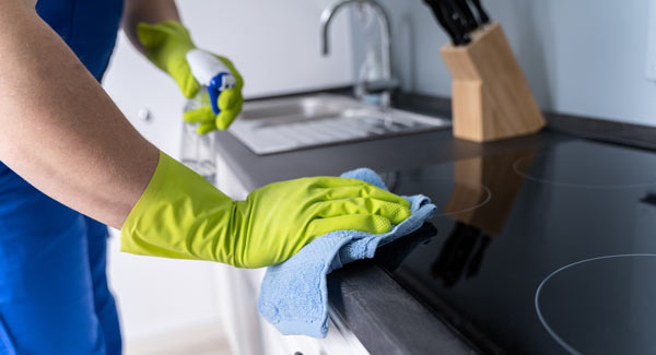 photo of person cleaning stove with cloth